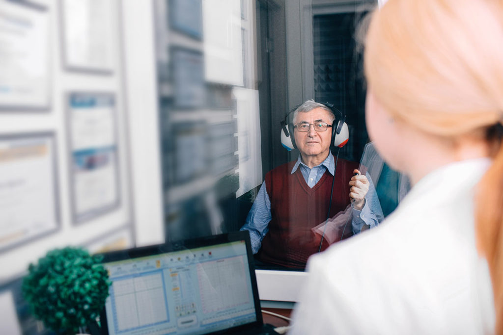 man taking a hearing test in isolated room